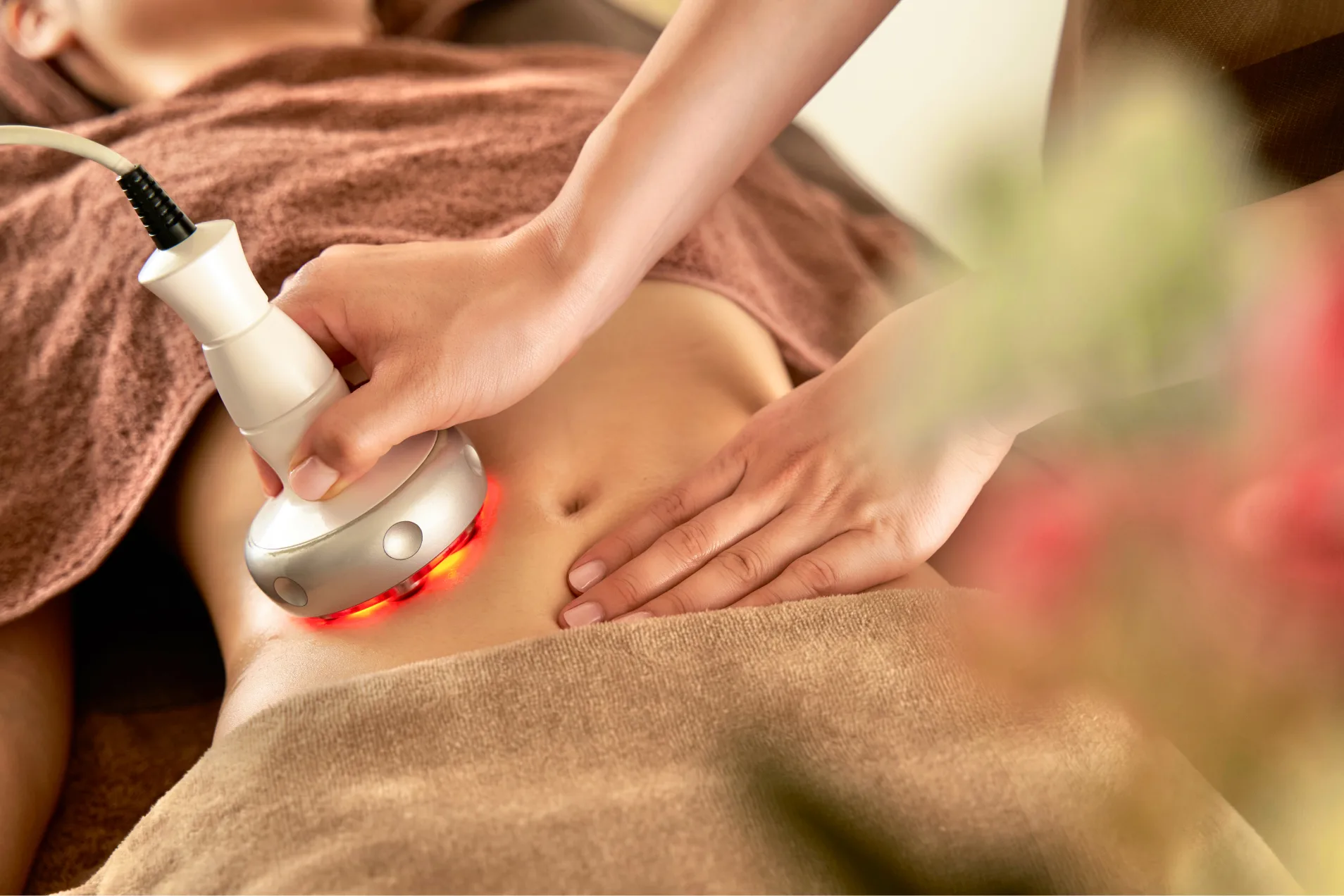 | QUALITAS(クオリタス)|痩身エステ付きパーソナルジム お腹にハイパーナイフのエステを受けている女性