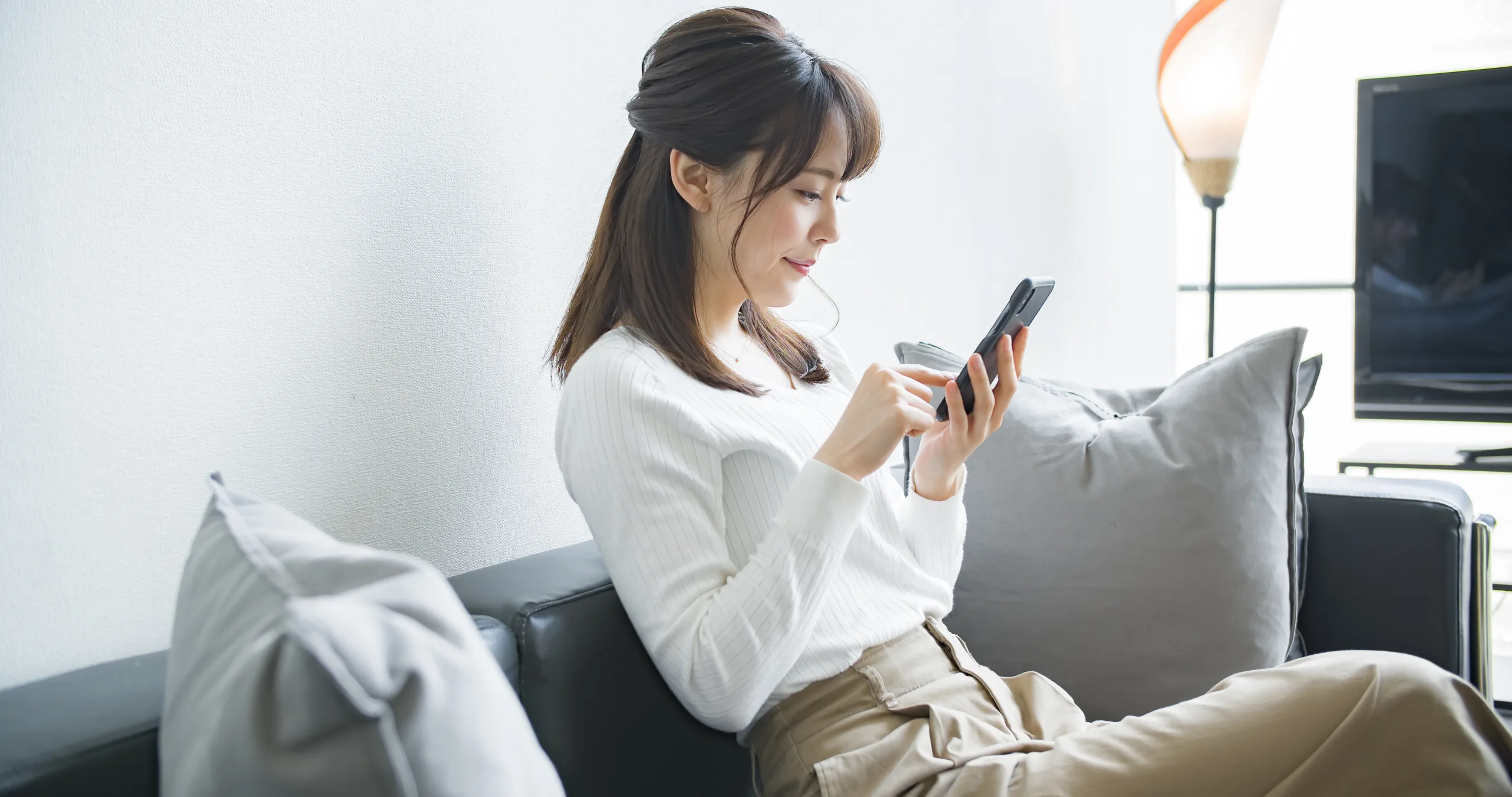 スマートフォン女性 - 表参道・外苑前で人気のパーソナルジム|QUALITAS青山外苑前店【トレーニング×痩身エステ】 スマホを操作している女性