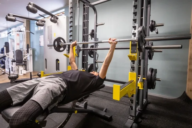 ベンチプレスで筋トレする男性