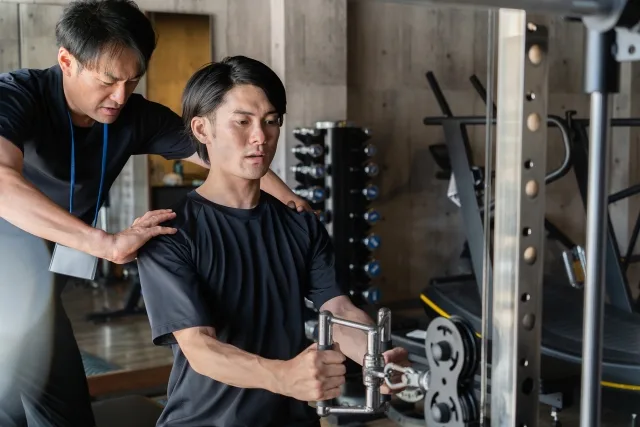 ジムでフォームチェックを受ける男性