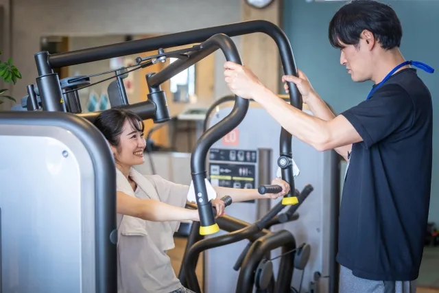 パーソナルトレーナーの指導を受ける女性