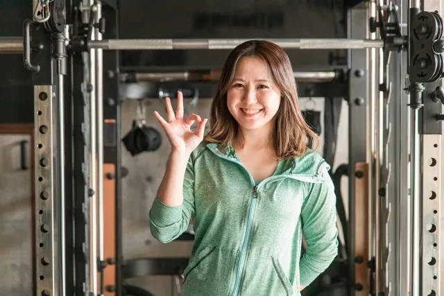 スポーツジムにいる笑顔のアジア人女性